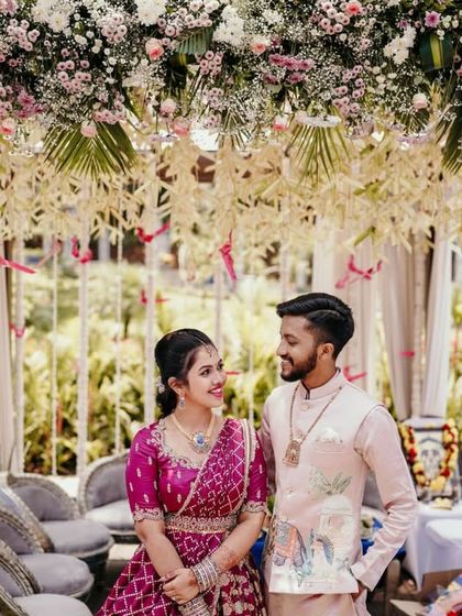 The couple sharing a look of love under a floral arch at their engagement party.