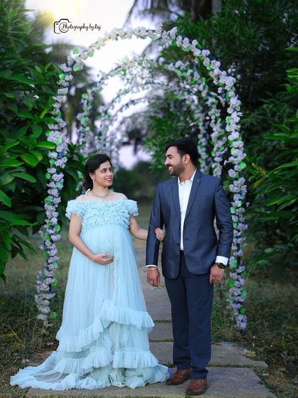 A romantic walk through a floral archway. This couple's maternity portrait captures a moment of shared joy and anticipation.