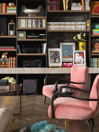 A detail of the bookcase in the Caitriona living room, showcasing a vibrant collection of art books and personal mementos. We believe a bookshelf should be a reflection of the owner's personality and passions.