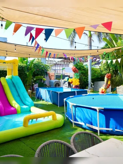 Our outdoor area is fully equipped for a pool party, with multiple pools, an inflatable slide, and colorful decorations to set the mood.