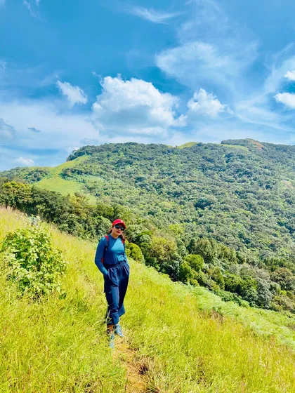 Posing on the trail with the beautiful green mountain in the background.
