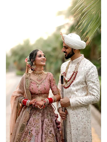 A classic and romantic portrait of a Punjabi Sikh couple on their wedding day. The soft outdoor lighting and their loving gaze create a timeless and beautiful image.