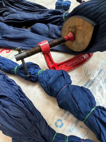 Fabric tied and clamped, ready for the indigo dye bath. These clamps and ties are the tools we use to create resist patterns in the Shibori style of dyeing.
