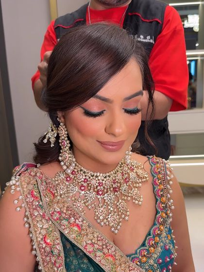 A close-up of the makeup, featuring soft pink eyeshadow and a flawless base. The look is elegant and sophisticated.