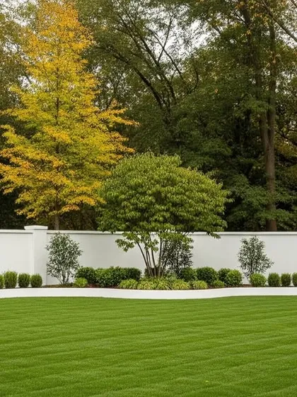 A formal landscape for a large property, featuring a striped lawn, a central feature tree, and symmetrical plantings along a clean white wall.