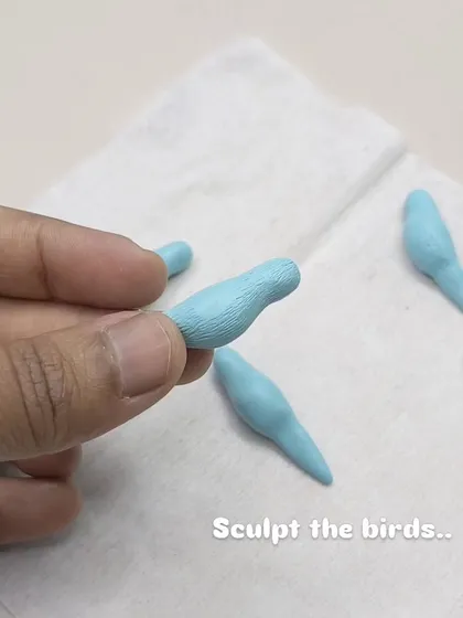 The process begins with sculpting the tiny birds, each one shaped by hand to give it character.