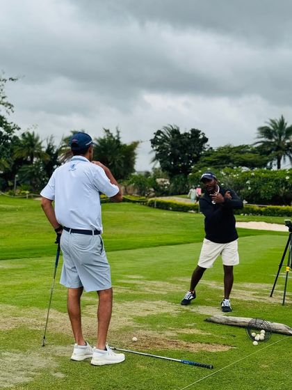 A senior coach mentors Coach Kiran on the range. Our development model includes mentorship from experienced professionals to accelerate growth.