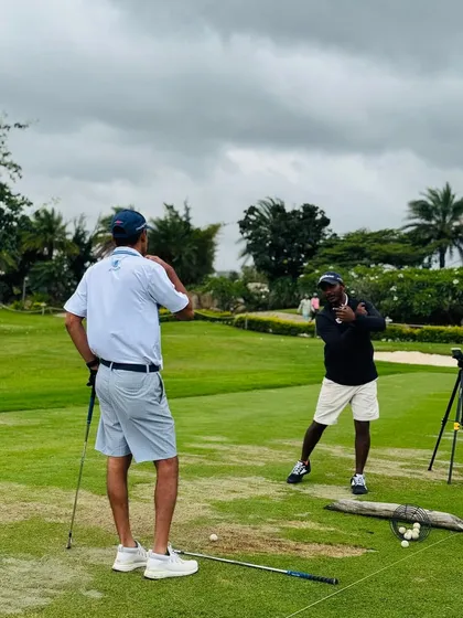 A senior coach mentors Coach Kiran on the range. Our development model includes mentorship from experienced professionals to accelerate growth.