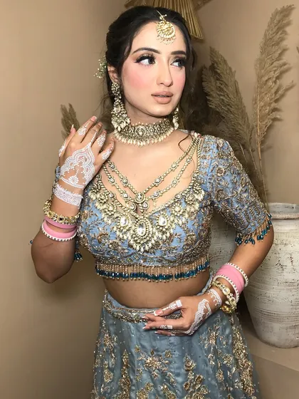 A beautiful shot focusing on the white henna and how it contrasts with the pink bangles and the heavy kundan jewelry.
