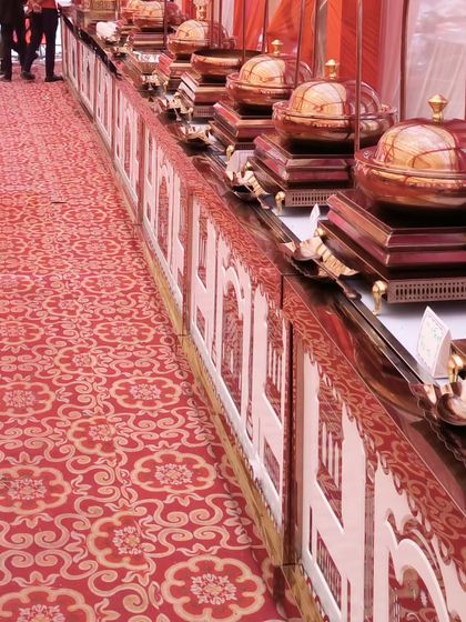 A perspective shot of our traditional wedding buffet line. The matching domed copper chafing dishes create a uniform and regal look, perfect for a classic Indian wedding feast.
