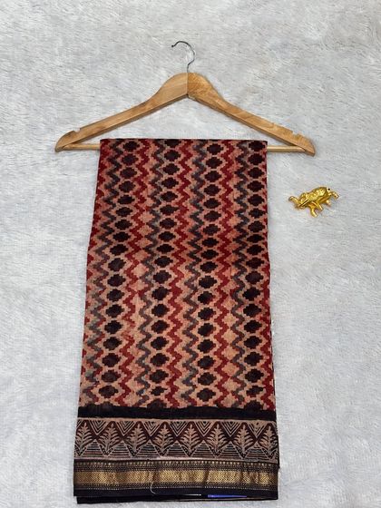 A unique geometric pattern on a Chanderi silk Bagru printed saree. The blend of red, black, and beige tones gives this traditional saree a contemporary edge.