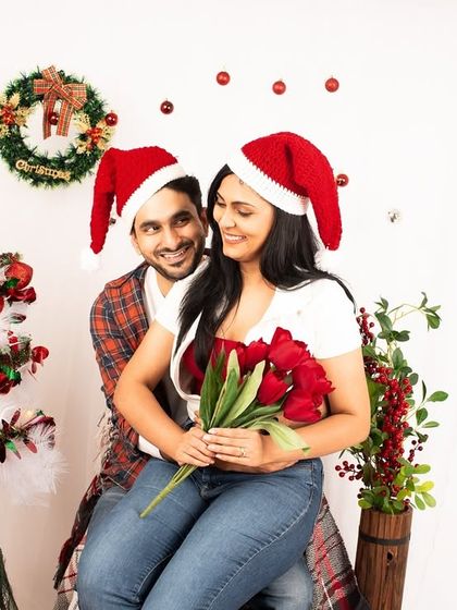 A playful couple's portrait from a Christmas mini-session. The Santa hats and festive props make for a fun and memorable holiday photo.
