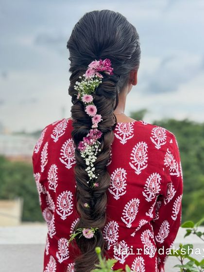 A clear, high-quality shot of the fishtail braid with fresh flowers, showcasing the healthy shine of the hair.