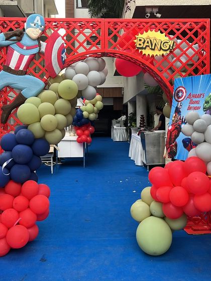 The entrance to Aliyaar's Marvel birthday party. We created a grand entryway with a red trellis, a Captain America cutout, and a balloon arch, setting the stage for a superhero adventure.