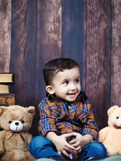 A toddler boy sitting with his teddy bear friends during his second birthday photoshoot.
