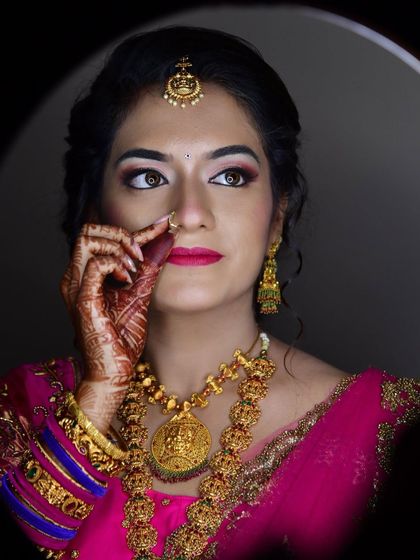A powerful close-up of Tanu, highlighting the dramatic eye makeup and rich lip color for her engagement ceremony.