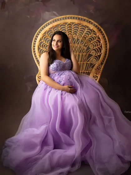 Feel like a queen for a day. Here, the mom-to-be looks absolutely regal in a flowing lavender gown, seated on my popular peacock chair. This prop adds a touch of royal elegance to any maternity session.