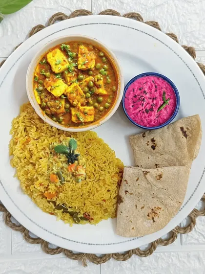 A beautifully plated meal featuring fragrant veg pulao, creamy mutter paneer, two soft rotis, and a vibrant beetroot raita. This is the kind of wholesome goodness I love to prepare.