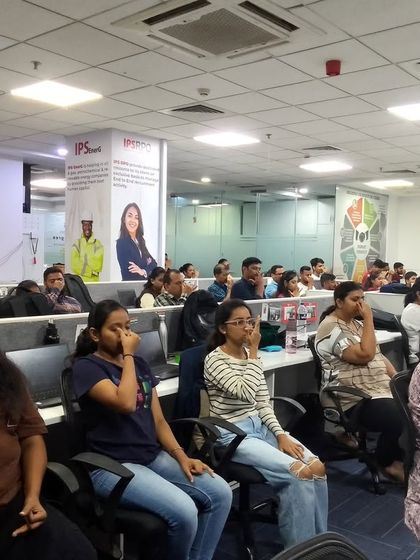A large group of employees practicing pranayama at their desks. It's powerful to see a whole team taking a collective breath, fostering a sense of unity and shared well-being.