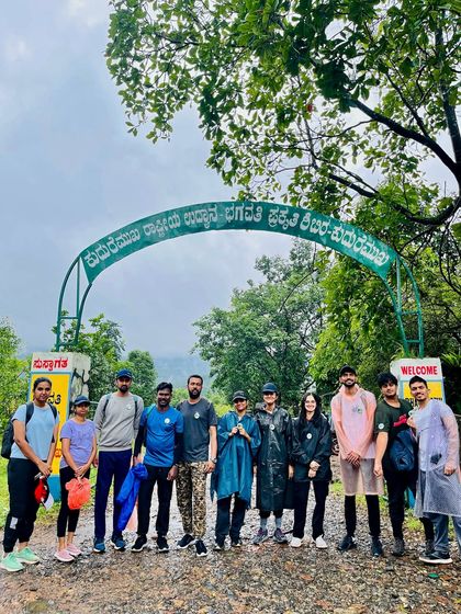 A group posing under the arch of the Kudremukha National Park entrance.