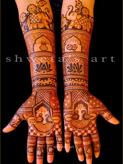 A beautiful example of a full-arm bridal design. The pattern includes bands of elephants, a kalash, and lotus flowers, with peacocks adorning the palms.