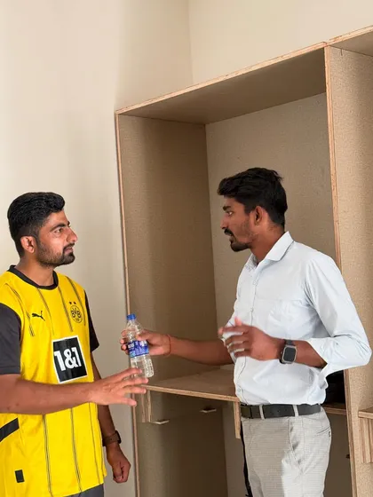 A quick break for a discussion with a team member amidst the wardrobe construction.
