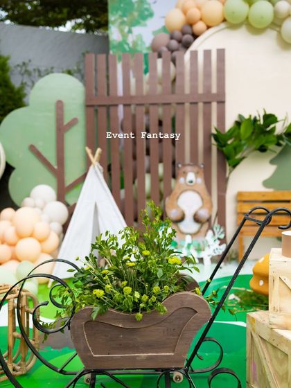 A wooden pram filled with greenery, another rustic and creative prop used to enhance the woodland party's atmosphere.