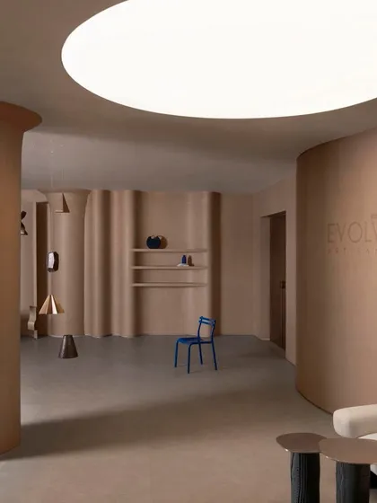 The showroom's open, flexible layout is punctuated by sculptural columns and a large circular ceiling light, creating a versatile and inspiring environment.