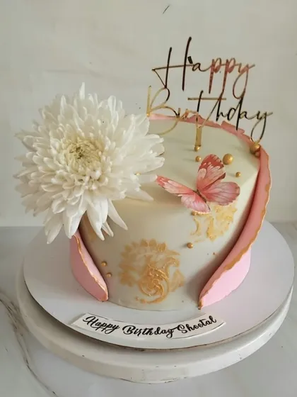 A pretty white and pink cake for Sheetal's birthday. The design features a large chrysanthemum, a delicate butterfly, and elegant gold stenciling. The flavor inside was a moist chocolate cake with luscious ganache.