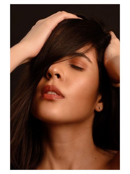 A close-up beauty portrait with a sensual and dreamy feel. The soft lighting and the model's expression create an intimate and captivating mood.