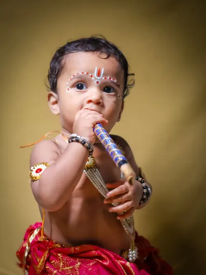 This 'Little Krishna' themed shoot is one of my favorites. I love capturing these divine, innocent moments, complete with traditional attire and a playful flute, against a rich, warm backdrop.