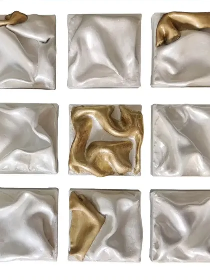 This is 'The Dancing Squad', a nine-panel abstract installation. The silver panels create a sense of unified, flowing movement, while the gold pieces act as lead performers, adding energetic bursts of light and contrast to the composition.