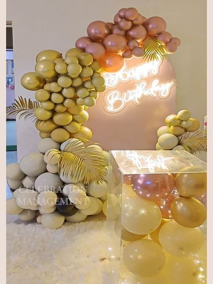 This view shows the different textures, from the soft rug to the smooth balloons and the golden palm leaves, all coming together.