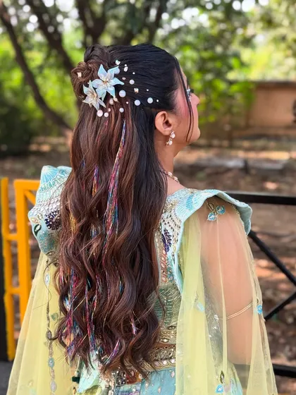 This angle highlights the colorful thread extensions woven into the hair, adding a playful and unexpected pop of color to the style.