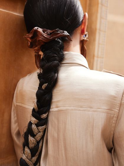 A close-up of the unique wooden hair accessory and the texture of the braid.