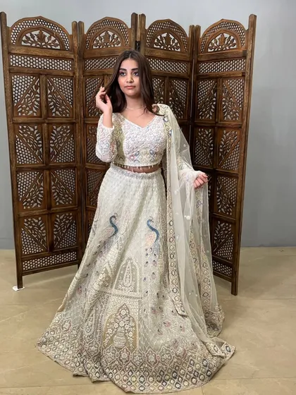 This off-white lehenga with intricate peacock embroidery is a masterpiece of craftsmanship.