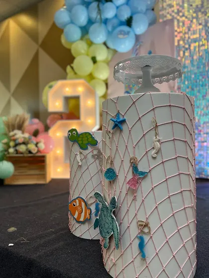 I pay attention to details, like these custom-decorated pedestals with a fishnet design and small sea creature figures for the Baby Shark theme.