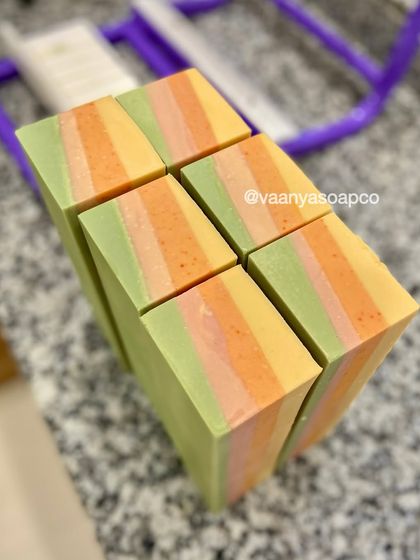 A top-down view of our freshly cut Tropical Escape soap bars. The layers of green, pink, orange, and yellow look like a tropical sunset.