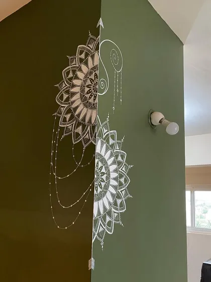 This semi-mandala was uniquely designed to wrap around a corner. The intricate white details on the olive green wall create a beautiful and continuous piece of art that flows from one space to another.