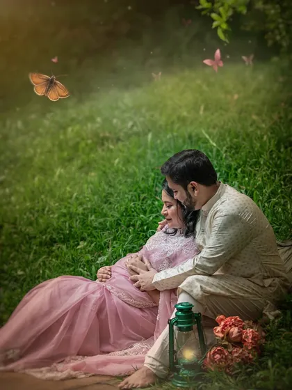 Adding a touch of digital magic, butterflies flutter around the couple in this enchanting portrait. This artistic edit enhances the fairytale quality of their romantic, nature-filled maternity shoot.