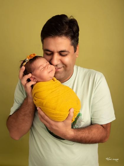 A father's love captured in a single frame. This close-up shot shows a new dad holding his swaddled baby, his expression full of adoration and tenderness.