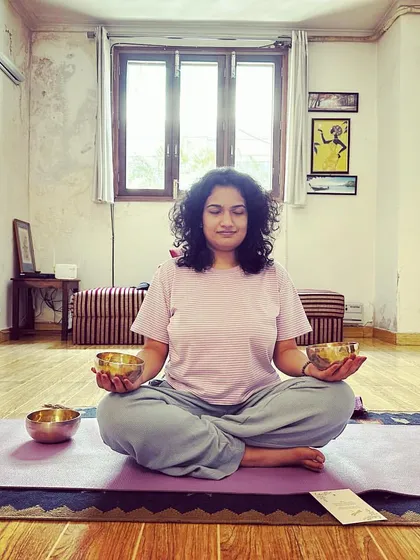 A client holding two smaller Tibetan bowls during a seated meditation. Holding the bowls allows you to feel the vibrations directly in your hands, which can be a very grounding and centering practice.