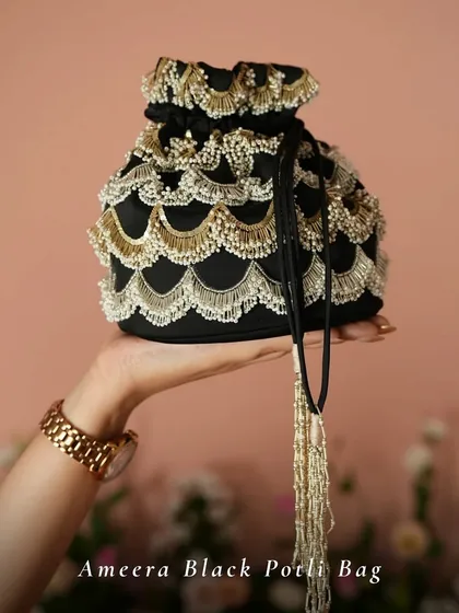 For a touch of classic glamour, the Ameera Black Potli Bag is a perfect choice. The scalloped pearl and gold beadwork against the black fabric creates a timeless and sophisticated look for any evening affair.