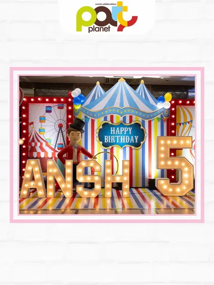 A classic circus-themed birthday stage with a big top backdrop, marquee letters, and a ringmaster prop for the perfect photo op.