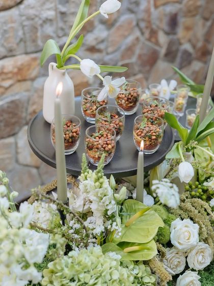 Another perspective of the appetizers in glasses, with the soft glow of candles creating an intimate and warm ambiance for the gathering.