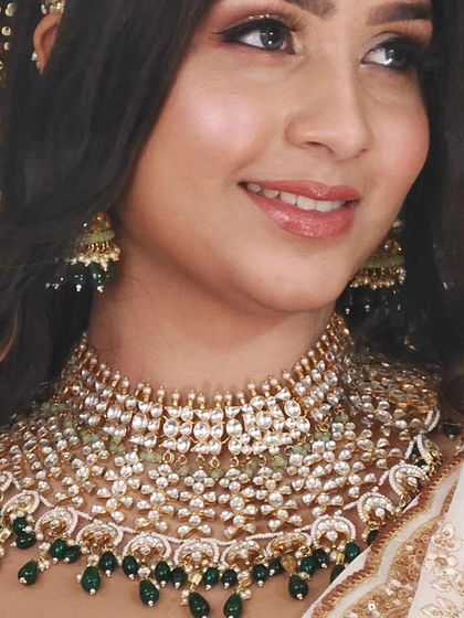 A close-up of a beautiful Pachi Kundan set with intricate details and green bead drops.