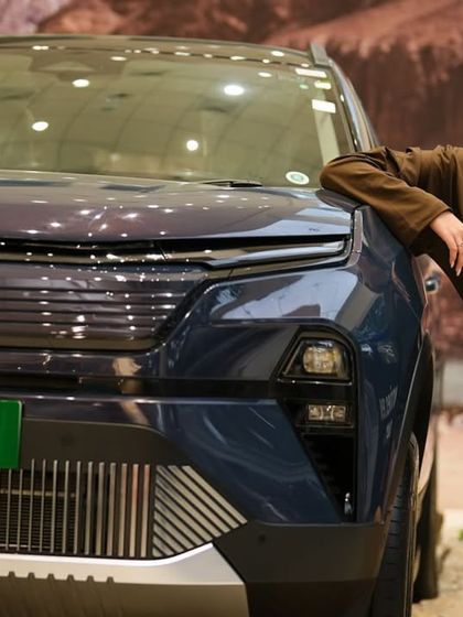 A close-up with the Harrier.ev, showcasing its modern design. This shot places me right next to the product, creating a direct association between my style and the car's aesthetic.