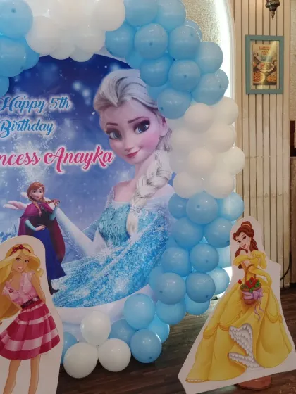 Another angle of the Frozen theme decor, showing the character cutouts of Barbie and Belle alongside the main backdrop.