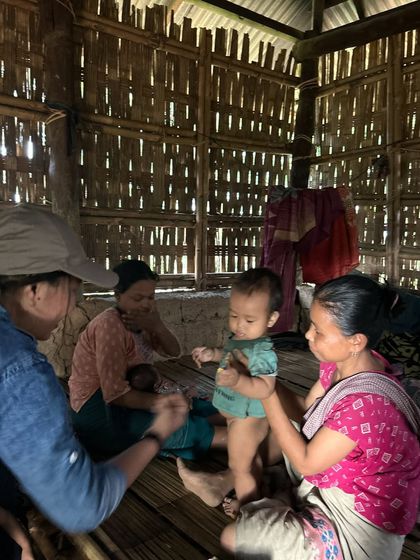 Interacting with mothers and their children during a village health survey.