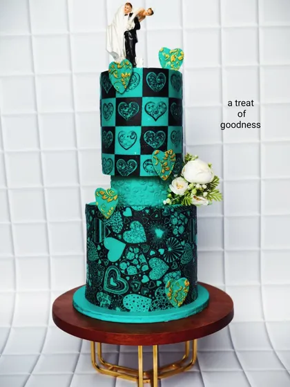This two-tier wedding cake shows how artistic you can get without fondant. I used a detailed stenciling technique with black cocoa on teal buttercream to create the intricate heart patterns, giving it a bold, modern, and unforgettable look.